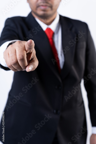 Closed up shot of an asian men pointing at the camera wearing a suit