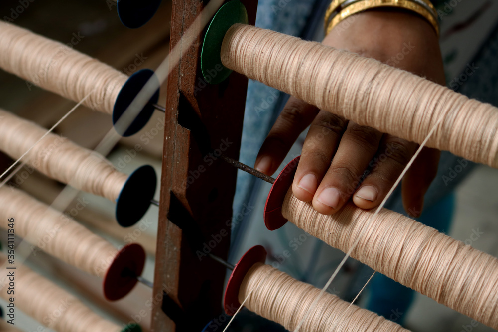 A Handloom Weaver preparing yarns in India. Stock Photo Adobe Stock