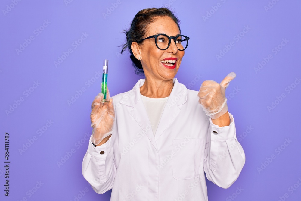 Middle age senior scientist woman wearing laboratory coat holding research test tube pointing and showing with thumb up to the side with happy face smiling Middle age senior scientist woman wearing laboratory coat holding research test tube pointing and showing with thumb up to the side with happy face smiling