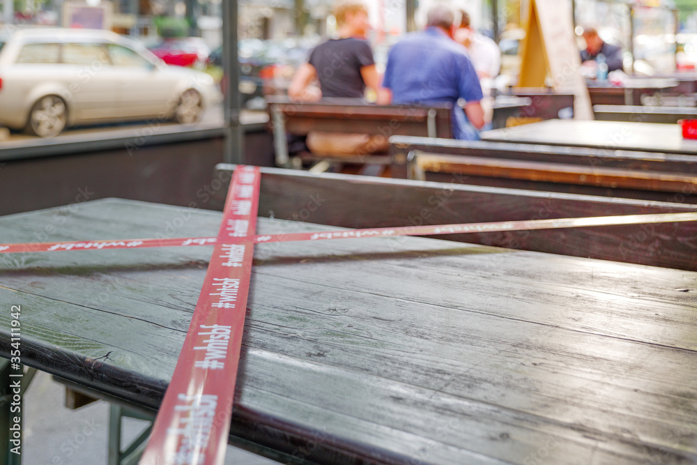 Selected focus view at Red and white caution on outdoor tables and seats area of restaurant during social distancing and New Normal from epidemic of COVID-19 virus. Selected focus view at Red and white caution on outdoor tables and seats area of restaurant during social distancing and New Normal from epidemic of COVID-19 virus.