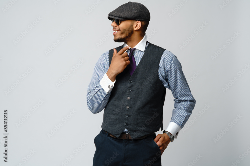 African-American man wearing cap, shirt and tie portrait over grey background African-American man wearing cap, shirt and tie portrait over grey background