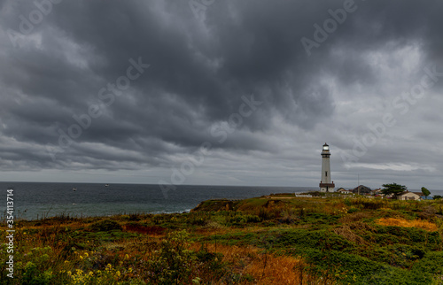 Pigeon Point Lighthouse with a very ominous dark cloud coming in from the Pacific ocean