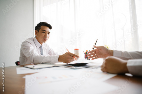 Image of two young businessmen working at office