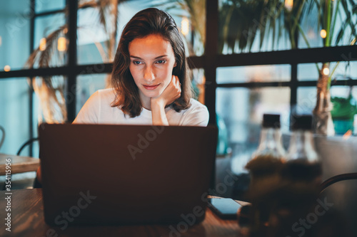 female girl using laptop at cafe workplace, hipster freelancer typing on keyboard laptop indoors restaurant, business woman working via portable computer internet technology