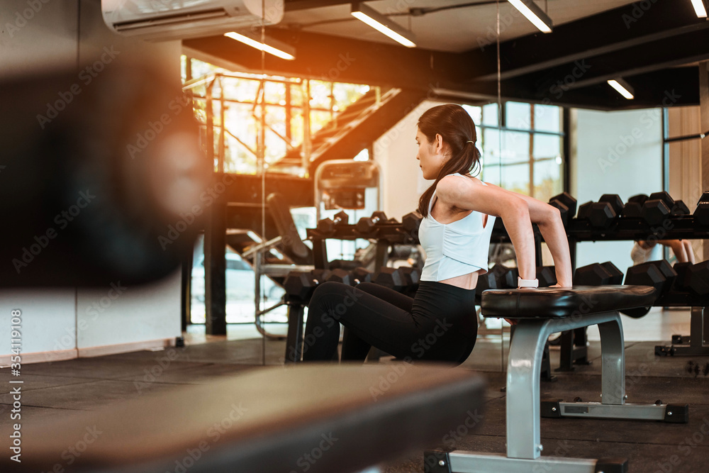 Beautiful young woman doing exercises with bench in gym Beautiful young woman doing exercises with bench in gym