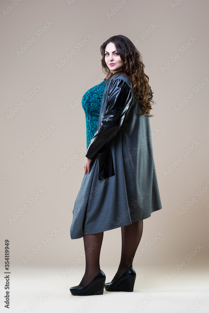 Plus size fashion model in a coat, fat woman on beige background Plus size fashion model in a coat, fat woman on beige background