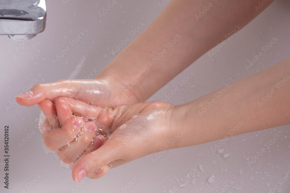 young girl soaped her hands and holds them under the tap young girl soaped her hands and holds them under the tap