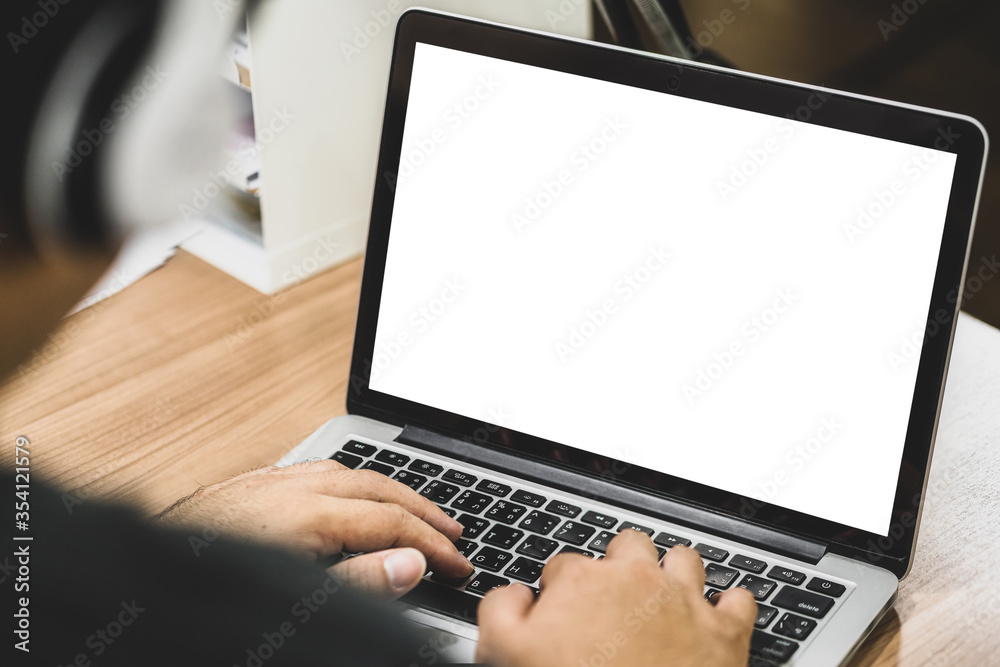 Asian business man wearing headphone and using laptop with white screen for creative and design in house