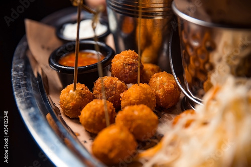 Foto Fried potato cheese balls or croquettes on a plate covered by parchment