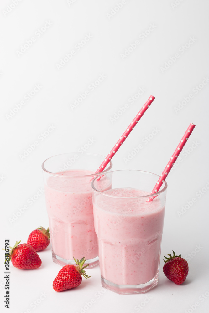 A glass of fresh strawberry smoothie on a white background. Summer drink shake, milkshake and refreshment organic concept. A glass of fresh strawberry smoothie on a white background. Summer drink shake, milkshake and refreshment organic concept.