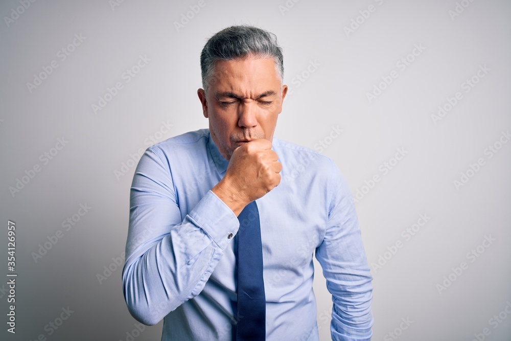 Middle age handsome grey-haired business man wearing elegant shirt and tie feeling unwell and coughing as symptom for cold or bronchitis. Health care concept. Middle age handsome grey-haired business man wearing elegant shirt and tie feeling unwell and coughing as symptom for cold or bronchitis. Health care concept.