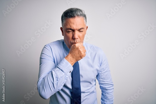 Middle age handsome grey-haired business man wearing elegant shirt and tie feeling unwell and coughing as symptom for cold or bronchitis. Health care concept.