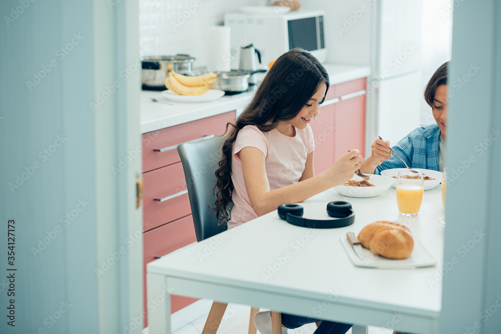 Friendly mirthful kids having breakfast in the kitchen Friendly mirthful kids having breakfast in the kitchen