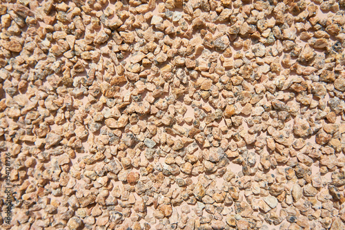 Wall surface covered with small ginger stones. Texture. 