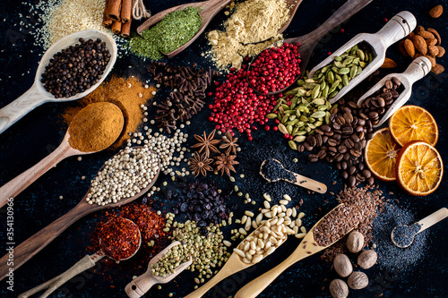 Many spices and herbs on the dark background table photo