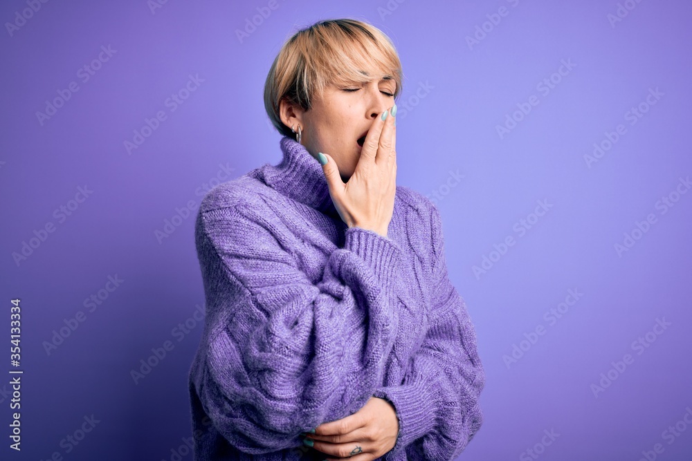 Young blonde woman with short hair wearing winter turtleneck sweater over purple background bored yawning tired covering mouth with hand. Restless and sleepiness. Young blonde woman with short hair wearing winter turtleneck sweater over purple background bored yawning tired covering mouth with hand. Restless and sleepiness.