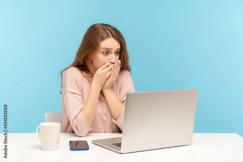 I won't tell anyone! Frightened woman employee covering mouth while communicating on video call, looking at laptop screen with terrified expression, found scary secret on internet. indoor studio shot I won't tell anyone! Frightened woman employee covering mouth while communicating on video call, looking at laptop screen with terrified expression, found scary secret on internet. indoor studio shot