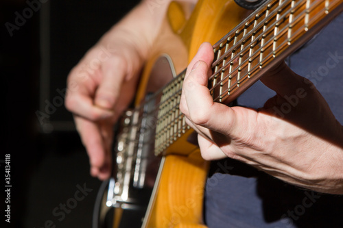 The bass player holds a chord with his left hand while playing music