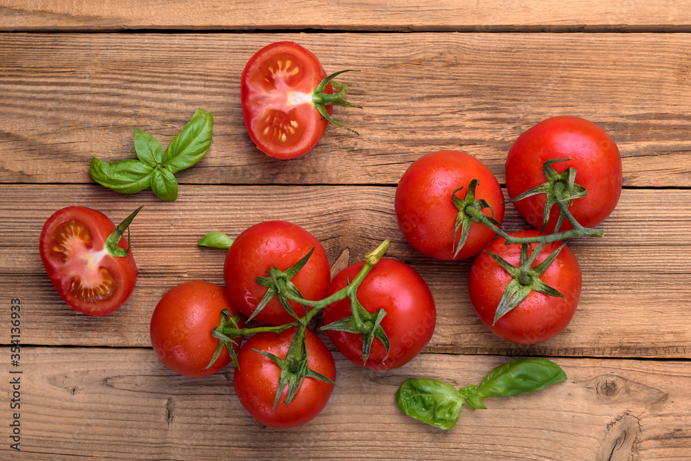 Fresh tomatoes with basil on wooden rustic background. Copy space, top view. Fresh tomatoes with basil on wooden rustic background. Copy space, top view.
