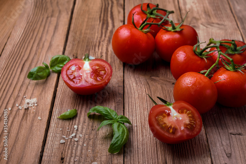 Fresh tomatoes with basil on rustic background.
