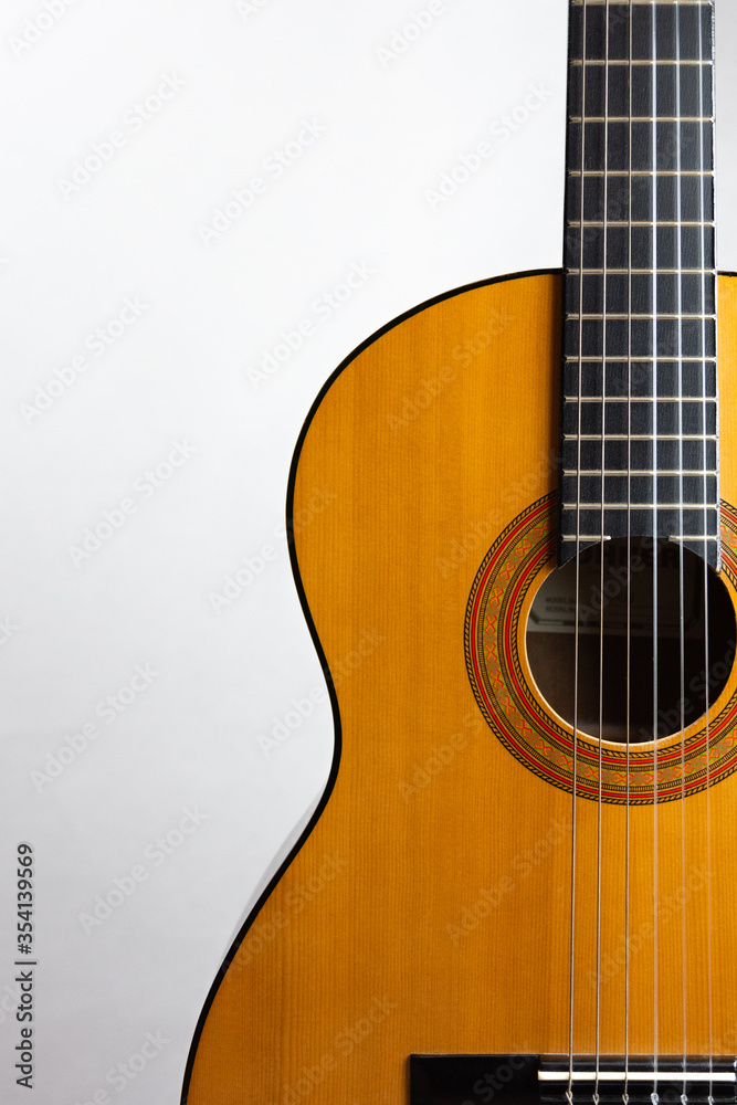 Acoustic guitar placed on the right
side in portrait format on a light background Acoustic guitar placed on the right
side in portrait format on a light background