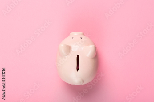 Ceramic pink piggy bank on pink background. Top view. Finance or banking concept.