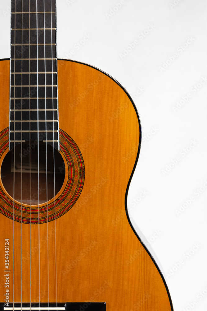 Acoustic guitar placed on the left
 side in portrait format on a light background