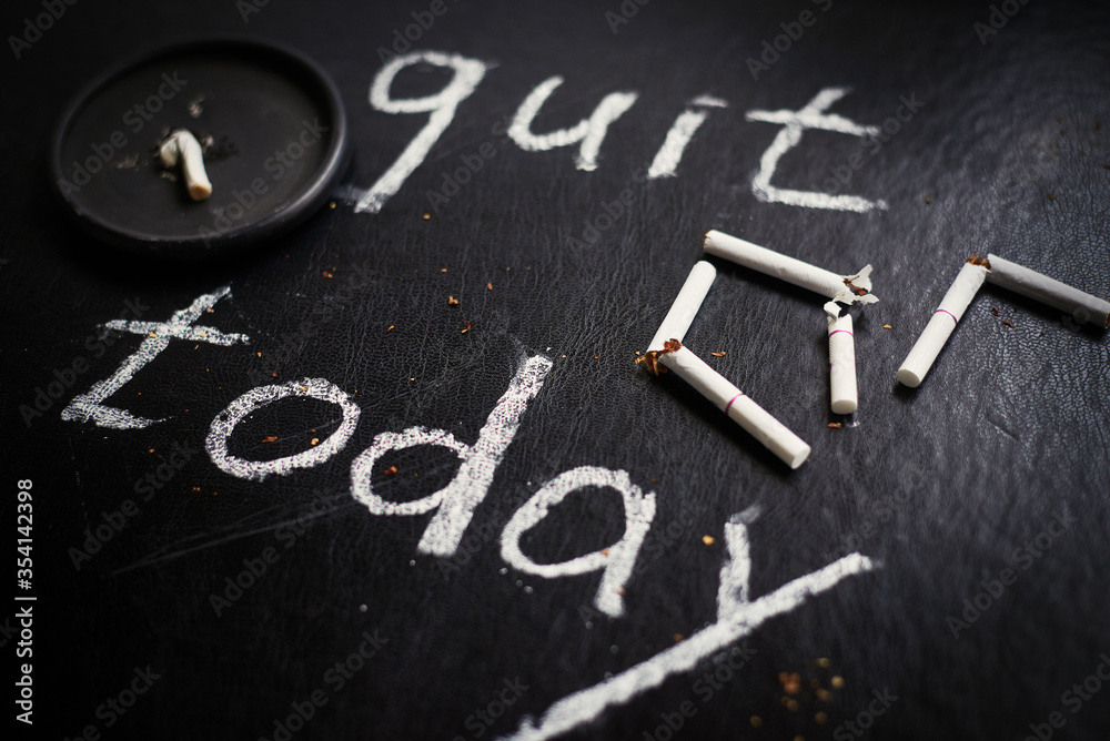 Fototapeta premium Stop smoking today concept. Broken cigarettes and inscription- quit today.