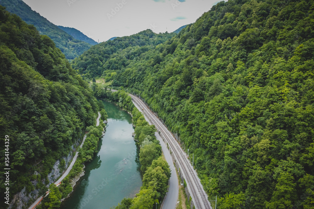 Panorama of tight river valley with cramped railway line and road next to a wide green Sava river close to Hrastnik and Trbovlje.