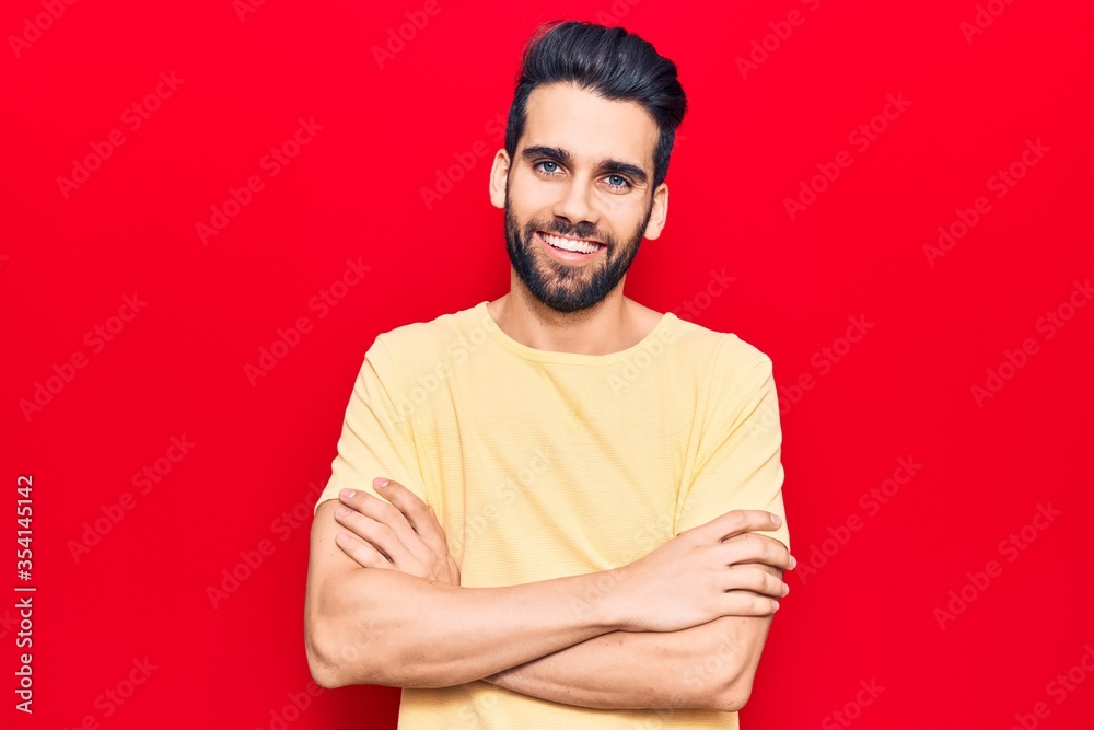 Obraz premium Young handsome man with beard wearing casual t-shirt happy face smiling with crossed arms looking at the camera. positive person.