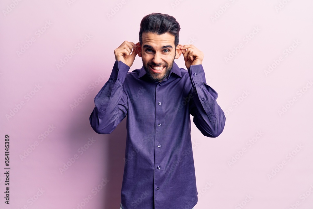Young handsome man with beard wearing casual shirt smiling pulling ears with fingers, funny gesture. audition problem Young handsome man with beard wearing casual shirt smiling pulling ears with fingers, funny gesture. audition problem