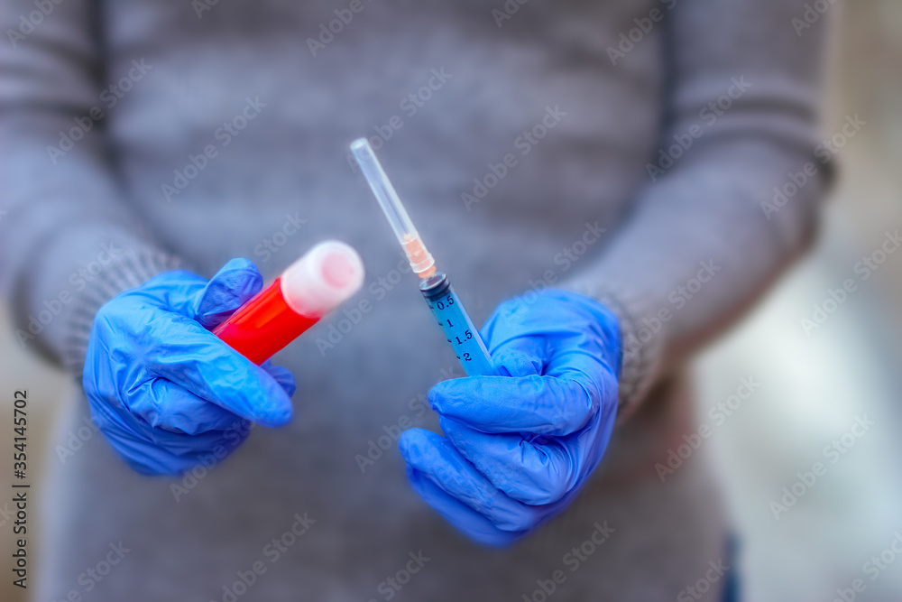 In the hands of a test tube with blood for analysis of the virus. Covid-19 is a danger to the infectious air population.