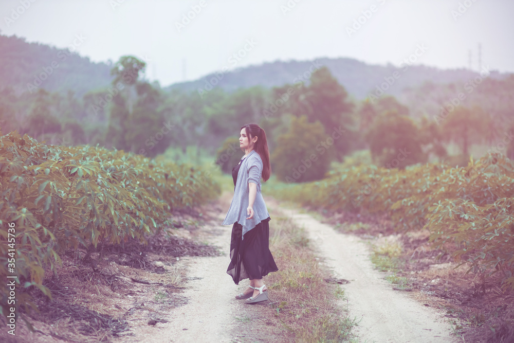 Carefree happy woman enjoying nature on the street with grass meadow and sunrise. - obrazy, fototapety, plakaty 