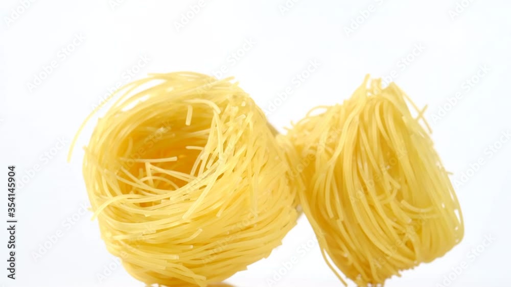 raw pasta capellini rotating isolated on white background. central composition raw pasta capellini rotating isolated on white background. central composition