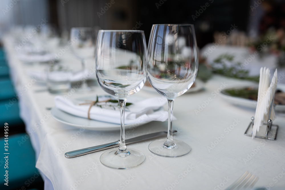 wedding table setting. two empty glasses in the foreground