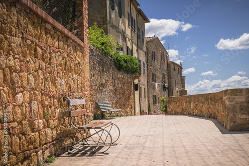 Fototapeta Naklejka Na Ścianę i Meble -  Sunny streets with colorful flowers with contrasting shades. Walk the Tuscan town