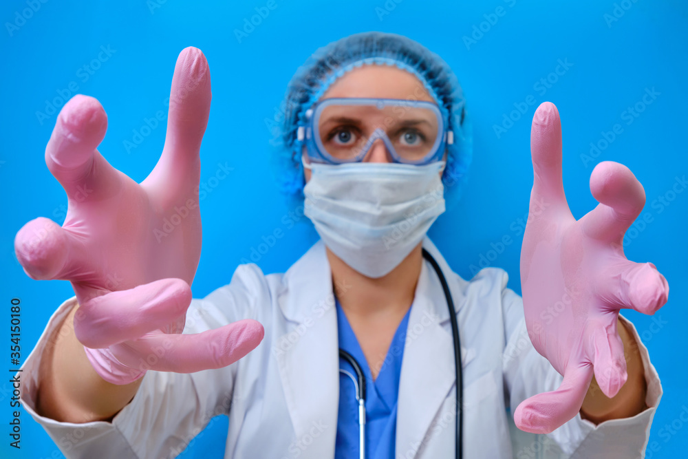 Creepy doctor's hands reaching forward to the patient as if in delirium. Frightening nurse in medical gloves on a blue background, close-up. Concept stay home because of a flu virus epidemic. Creepy doctor's hands reaching forward to the patient as if in delirium. Frightening nurse in medical gloves on a blue background, close-up. Concept stay home because of a flu virus epidemic.