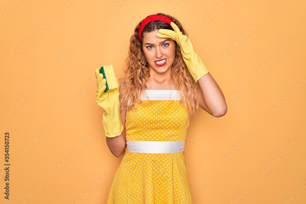 Young beautiful blonde woman with blue eyes cleaning using gloves and cleaner scourer stressed with hand on head, shocked with shame and surprise face, angry and frustrated. Fear and upset Young beautiful blonde woman with blue eyes cleaning using gloves and cleaner scourer stressed with hand on head, shocked with shame and surprise face, angry and frustrated. Fear and upset