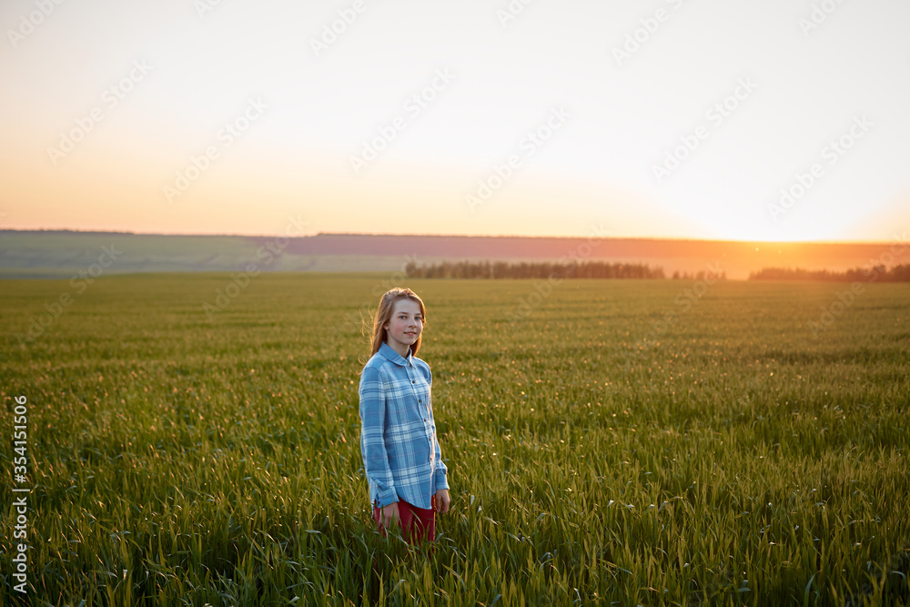 portrait of a teenage girl in a field at sunset