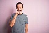 Middle age hoary man wearing casual striped t-shirt standing over isolated pink background looking confident at the camera with smile with crossed arms and hand raised on chin. Thinking positive.