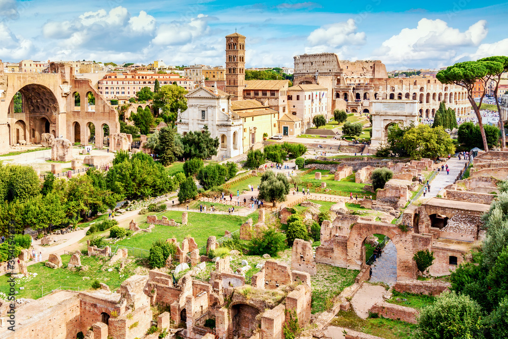 Aerial panoramic cityscape view of the Roman Forum and Roman Colosseum in Rome, Italy. World famous landmarks in Italy during summer sunny day.