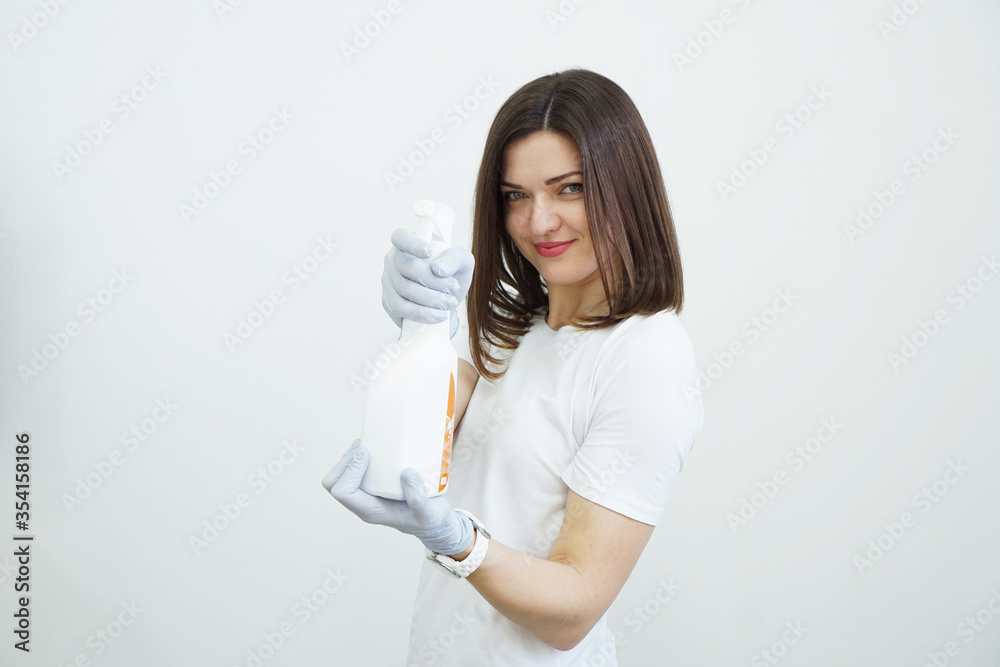 Woman holds spray bottle with antiseptic or detergent like guns. Health or cleaning concept Covid-2019, on white background Woman holds spray bottle with antiseptic or detergent like guns. Health or cleaning concept Covid-2019, on white background