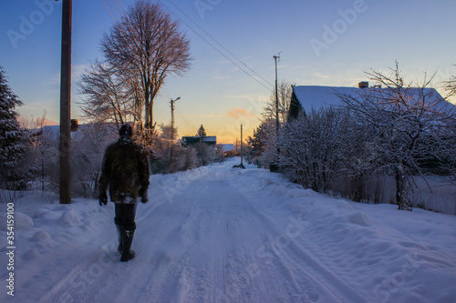 Fotografía man walking in snow russian village