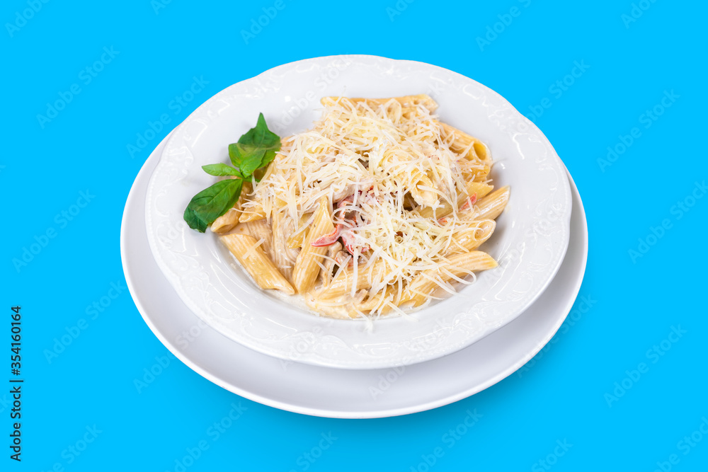 Delicious Italian penne pasta with cheese and pepper and fresh mint on blue background Delicious Italian penne pasta with cheese and pepper and fresh mint on blue background