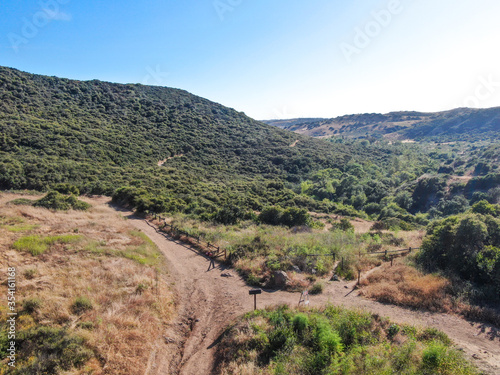 Aerial view of Los Penasquitos Canyon Preserve during dry season. Urban park with mountain, forest and trails in San Diego, California. USA