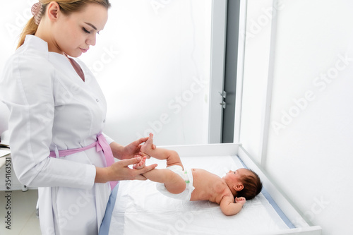 medicine, healthcare and pediatrics concept - female pediatrician or neuropathist doctor or nurse checking baby patient's at clinic or hospital photo