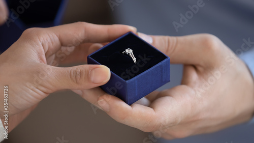 Close up of caucasian man present box with beautiful wedding diamond ring to loving woman, affectionate male make marriage proposal to beloved female lover, engagement, marry me concept