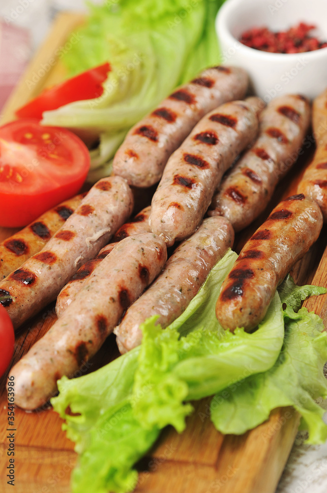 grilled smoked sausages, lettuce leaves, tomatoes grilled smoked sausages, lettuce leaves, tomatoes
