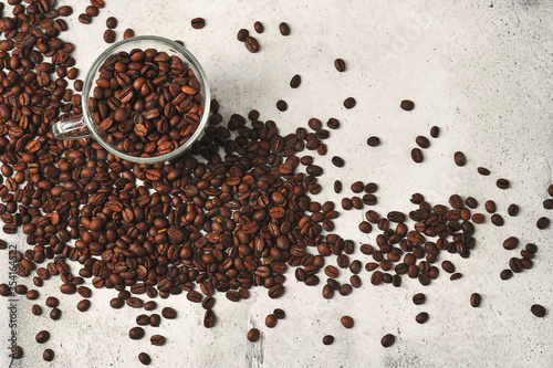 coffee beans in a transparent glass mug on a background of coffee beans