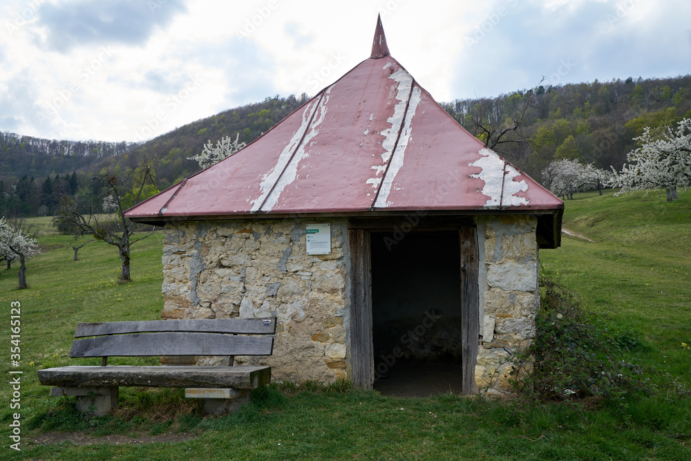Obraz premium Stone hut for sheep shepherds on a green meadow in spring in south germany